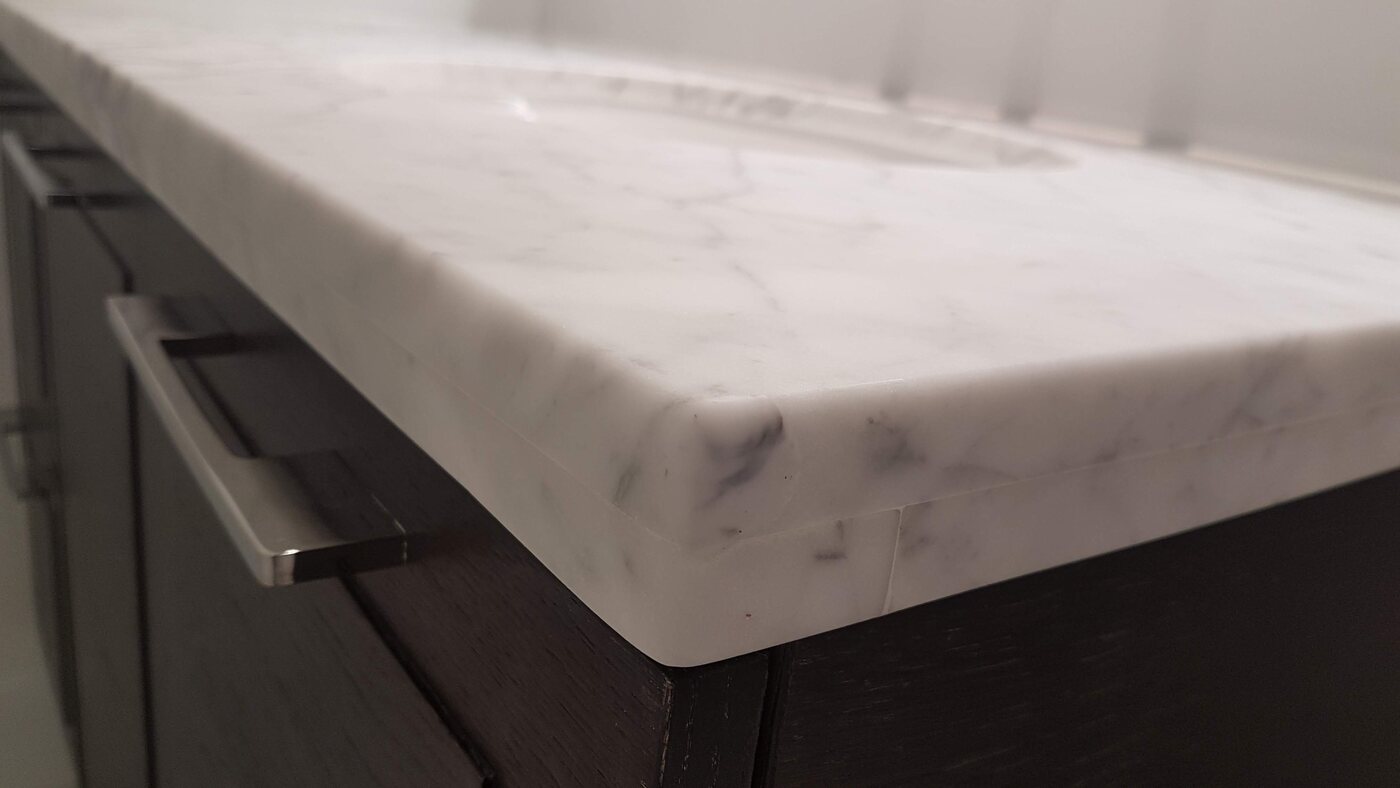 White marble countertop corner rebuilt and polished so the repair is invisible