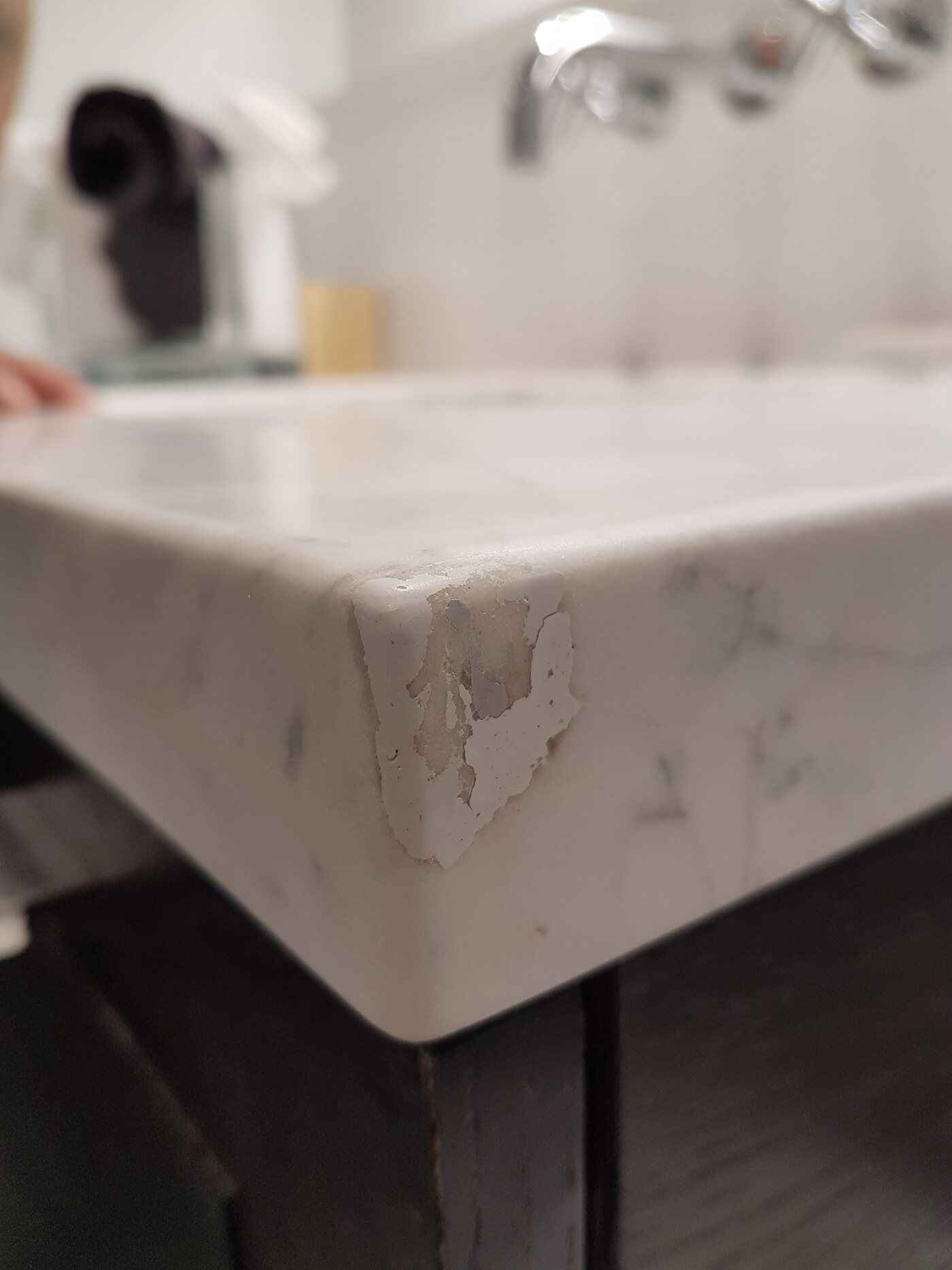 Chipped and badly repaired corner on a white marble countertop