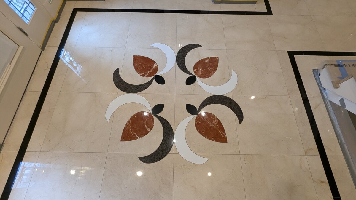 Polished marble entry floor with an inlaid stone mosaic medallion